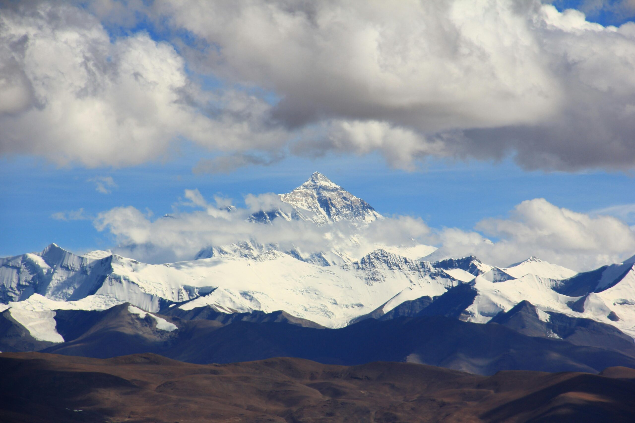 Trekkers at Everest Base Camp with Mount Everest and surrounding peaks